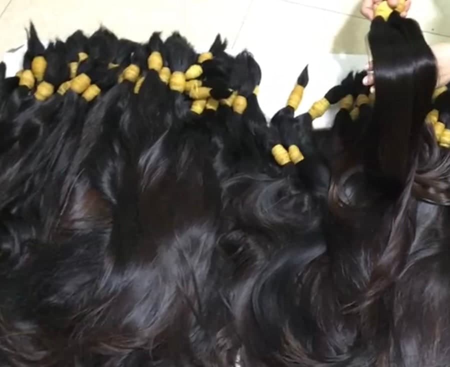 Mèches de cheveux naturels bruts regroupées en bundles, avant tri et confection
